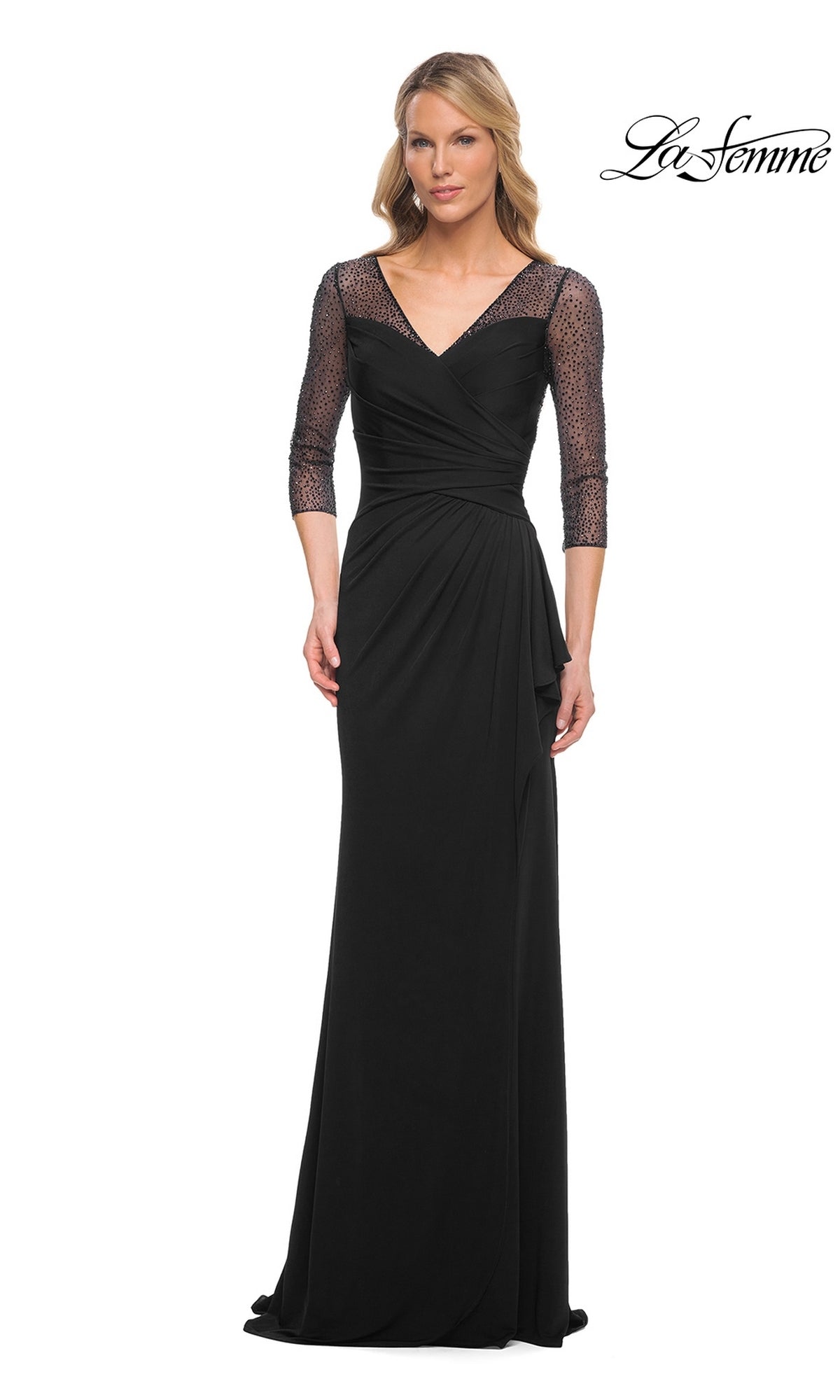 A woman wears the Long Formal Dress: La Femme 30028 in black, featuring a floor-length silhouette and three-quarter mesh sleeves, against a white background.